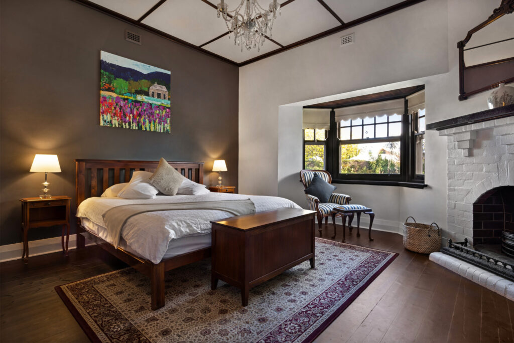 Spacious master bedroom with fireplace and high ceilings in luxury Barossa Valley accommodation
