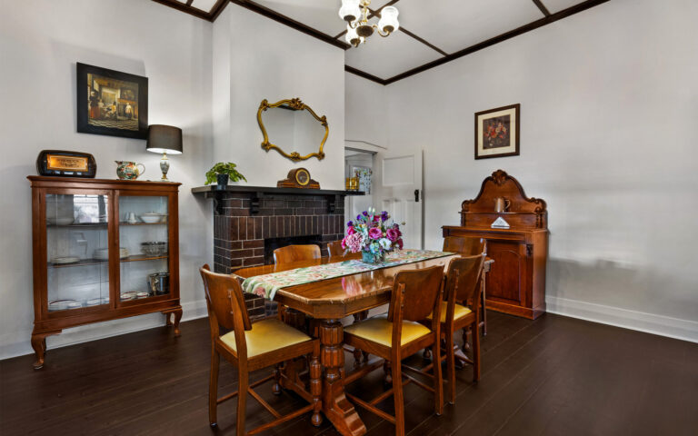 Elegant dining room with fireplace and period furnishings in restored Barossa heritage home