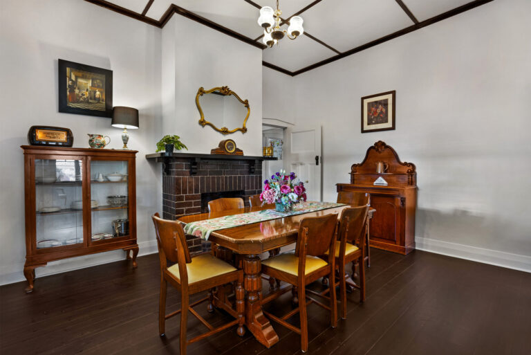Elegant dining room with fireplace and period furnishings in restored Barossa heritage home
