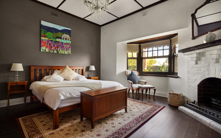 Spacious master bedroom with fireplace and high ceilings in luxury Barossa Valley accommodation