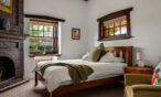 Comfortable heritage bedroom with timber furnishings and original fireplace at Barossa Valley retreat