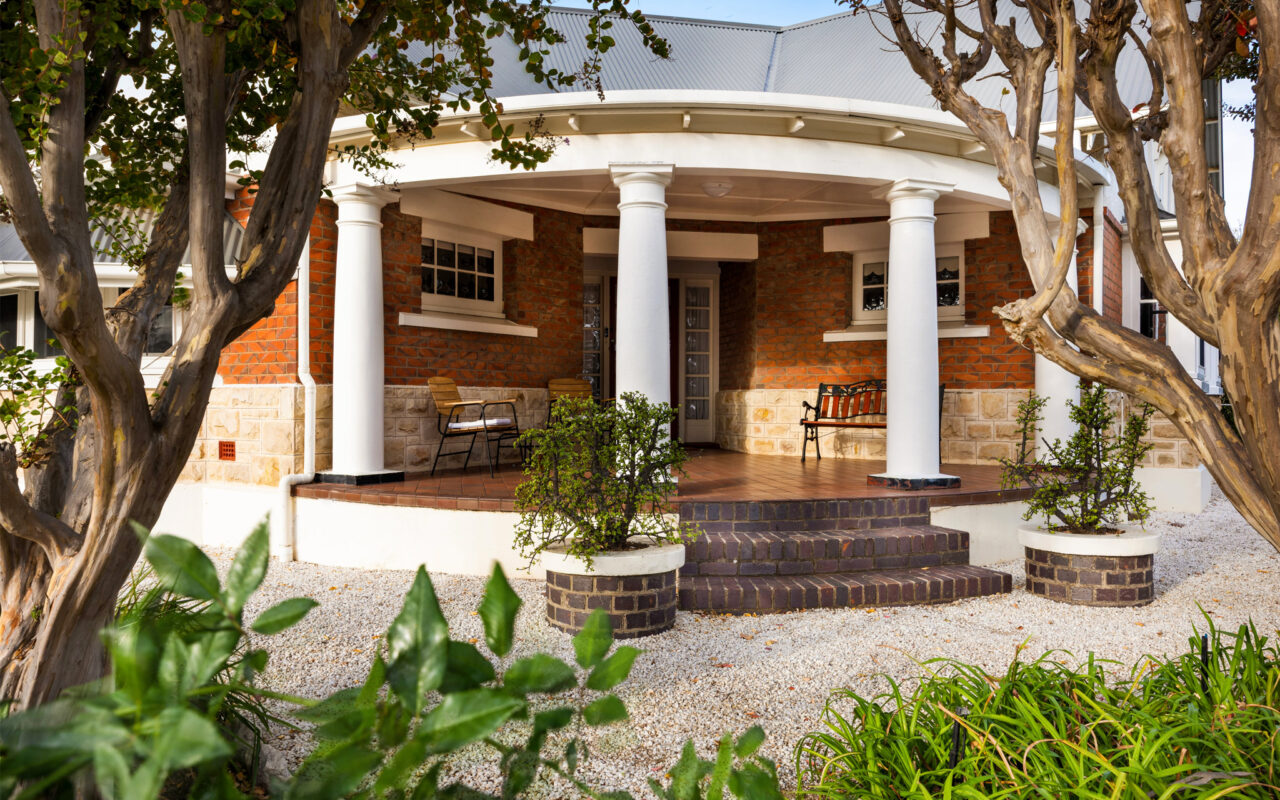 Traditional wraparound veranda entrance surrounded by gardens at heritage Barossa Valley accommodation